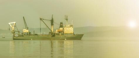 pescar barco de jabeguero en el bahía en el carreteras en Vladivostok en suave luz de sol foto