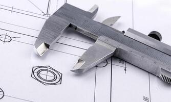 Old metal caliper and engineering drawing. Close up photo
