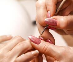 Master of manicure paints nails. Selective focus photo