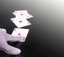 hand of the dealer in white gloves in a casino handing out cards photo