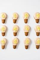 AI generated Creative idea concept. Top view light bulbs cookies on white background. AI generated photo