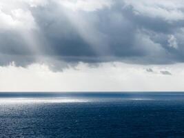 beams of lights hit the blue ocean photo