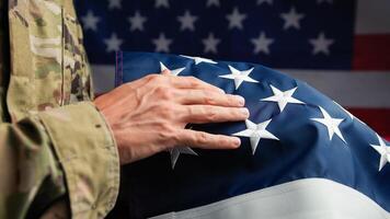 mano de un veterano conmovedor estrellas de Estados Unidos bandera foto