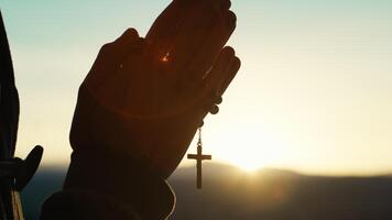 Man prays at sunset with rosary photo