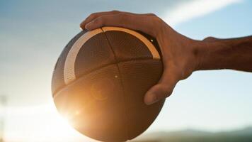 Holding American football ball at sunset photo