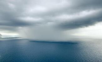 Cloudburst over the ocean near the coast photo