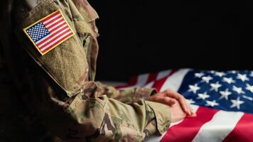 mano de un veterano conmovedor estrellas de Estados Unidos bandera foto