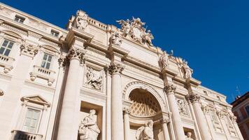 Historical statues and building at Trevi Fountain photo