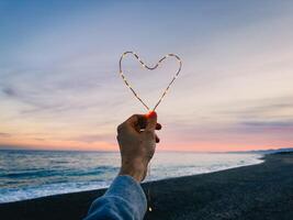 Celebrating the valentines day. heart symbol made with bright fairy lights photo