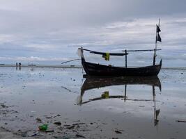 fishing boats stranded on the beach, preparing to leave by waiting for the tide photo