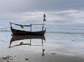 fishing boats stranded on the beach, preparing to leave by waiting for the tide photo