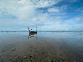 fishing boats stranded on the beach, preparing to leave by waiting for the tide photo