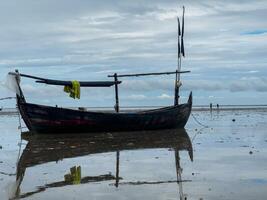 pescar barcos varado en el playa, preparando a salir por esperando para el marea foto