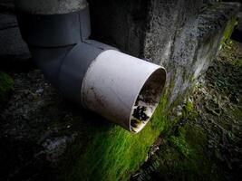 un plomería de agua desagüe desde el techo con un sucio tubo foto