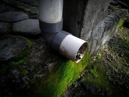 un plomería de agua desagüe desde el techo con un sucio tubo foto