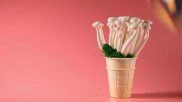 shimeji mushrooms with green moss in green ice cream cone, on pink background photo