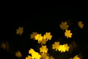 glare, bokeh, lights in the shape of clover leaves on a black background. for overlay photo