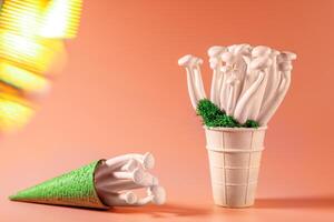 shimeji mushrooms with green moss in an ice cream cone, on peach fuzz background photo