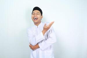 portrait of laughing asian muslim man presenting to side isolated on white background photo