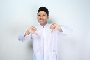 funny muslim asian man giving thumbs down isolated on white background photo