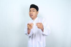 confused asian muslim man pointing at camera isolated on white background photo