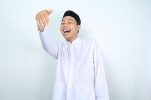 excited asian muslim man show inviting gesture with laugh isolated on white background photo