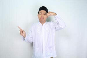 sad asian muslim man crying with pointing to empty space isolated on white background photo