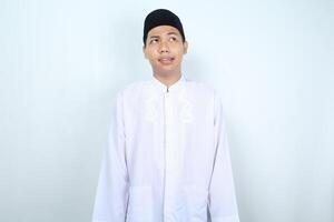 asian muslim man looking above with confused face isolated on white background photo