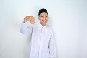 smiling muslim asian man show inviting gesture with looking at camera isolated on white background photo