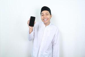 smiling asian muslim man showing blank phone screen isolated photo