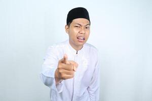 confused asian muslim man pointing at camera isolated on white background photo