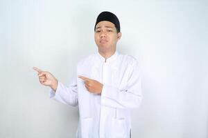 stressed muslim man asian pointing to empty side isolated on white background photo