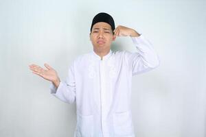 sad asian muslim man crying with presenting hand to empty side isolated on white background photo