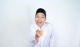 funny asian muslim man pointing hand forward with surprised expression isolated on white background photo