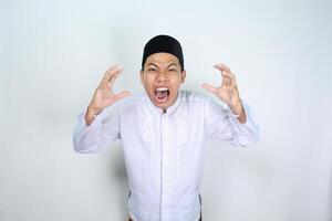 stressed asian muslim man screaming with raised hand isolated on white background photo