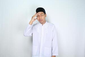 stressed asian muslim man feeling dizzy isolated on white background photo