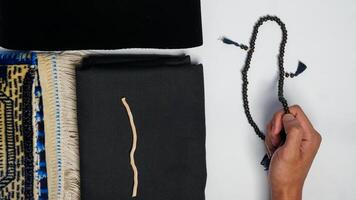 Muslim prayer equipment with hands praying on white background photo