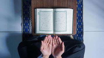 parte superior ver de un musulmán hombre leyendo el Corán y oración foto