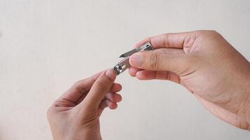 close up hand care with nail clipper. man is cleaning and cutting nails photo