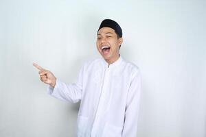 attractive muslim asian man pointing to the right side and shouting with mouth open isolated on white background photo