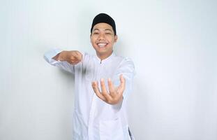 happy muslim asian man pointing to empty hand, imagine holding bowl, isolated on white background photo