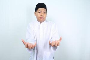 thoughtful asian muslim man show empty palm holding imaginary food plate isolated on white background photo