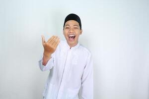 asian man muslim isolated on white background show inviting gesture with scream photo