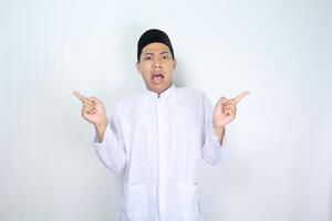 muslim asian man pointing beside with shocked expression isolated on white background, looking at camera photo