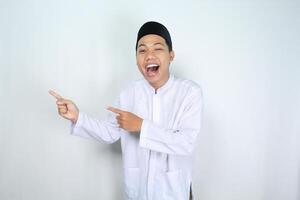 attractive muslim asian man pointing to the right side and shouting with mouth open isolated on white background photo