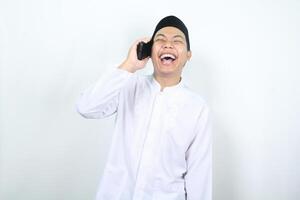 delighted asian muslim man laughing while talking on the phone isolated photo