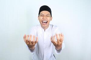 asian muslim man holding imaginary bowl with empty palm and laughing expression isolated on white background photo