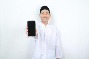 smiling asian muslim man showing blank phone screen isolated photo