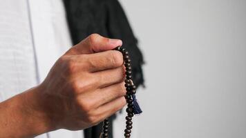 close up of man's hands praying with prayer beads photo