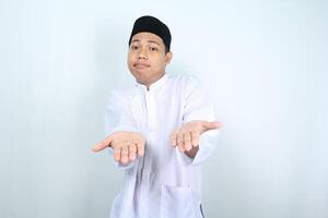 confused asian muslim man presenting empty palm at camera isolated on white backround photo